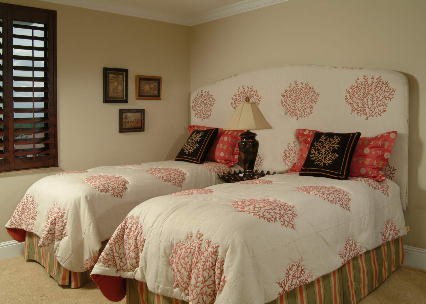 Guest bedroom with two beds and tan wallpaper